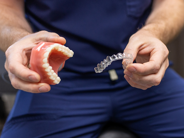 Woman comparing Invisalign and metal braces