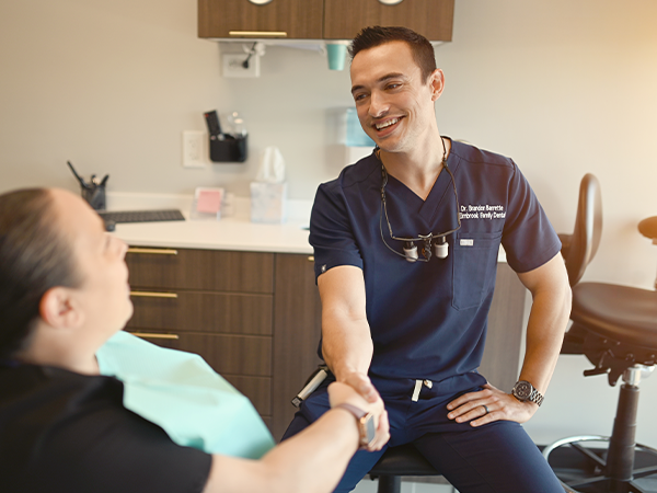 Dentist talking to young dental patient and parent