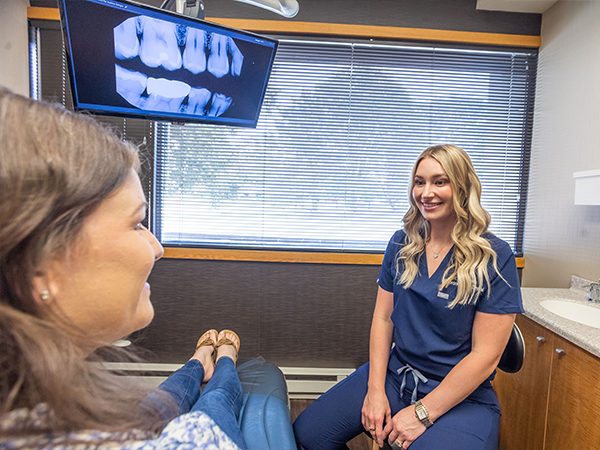 Dentist talking to young dental patient and parent