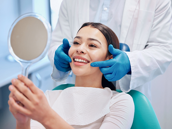 Dentist talking to young dental patient and parent